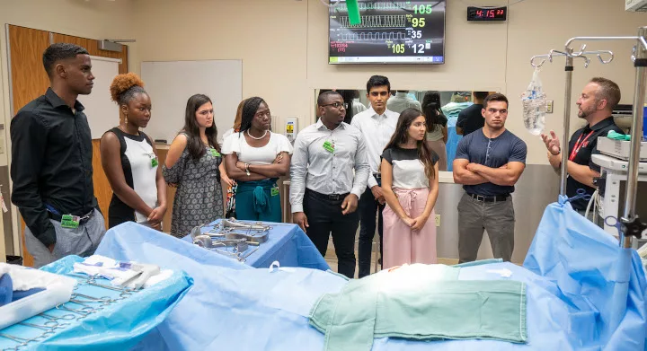 Students listening to a speaker in an operating room