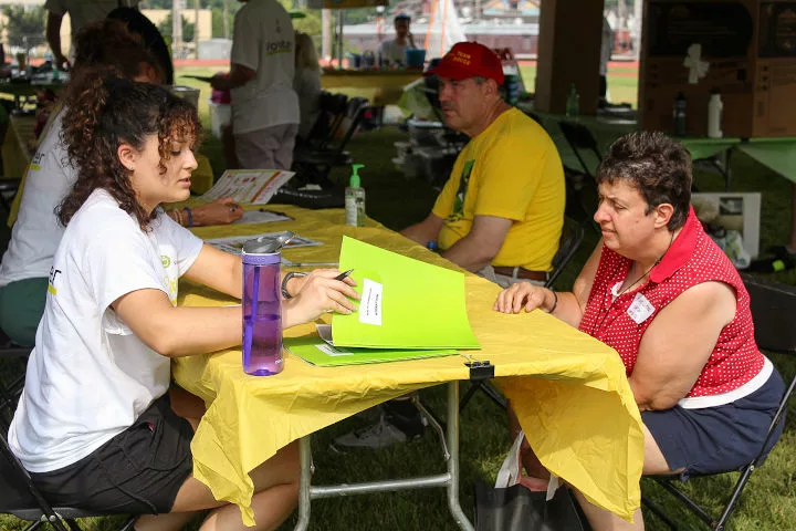 A student talking with a Special Olympics athlete at a table