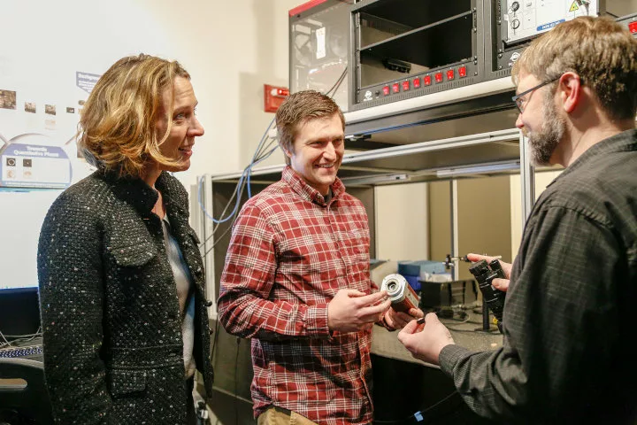 Three people talking in a lab