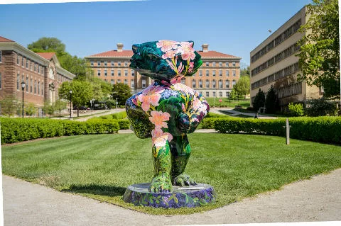 A statue of Bucky Badger with images of flowers and green plants on the surface