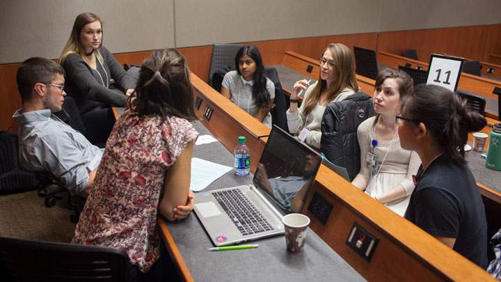 Students facing each other in a small-group discussion