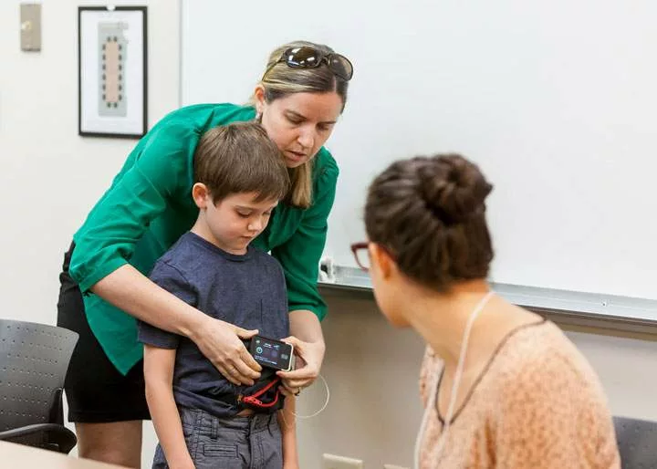 A young boy and his mother talking to a medical student