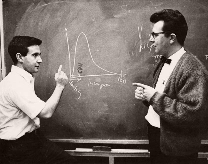 Two academics working at a chalkboard
