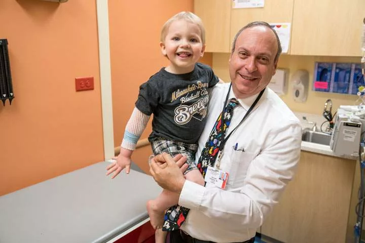 A doctor holding a young patient