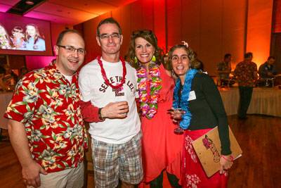 Four people posing for a photo at a luau