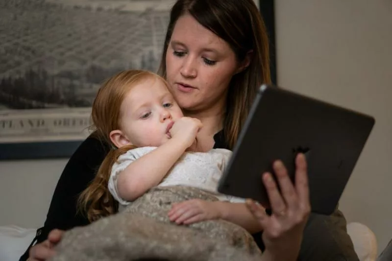 A woman and her child visit via telehealth with a physician